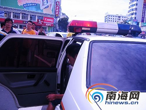 交警将无证驾驶"泡妞摩托车"的年轻男子带上警车 (南海网记者冯丹摄)