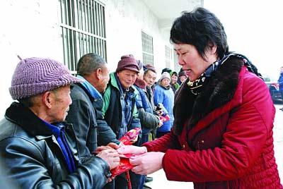 魏小媛向村民派发红包。