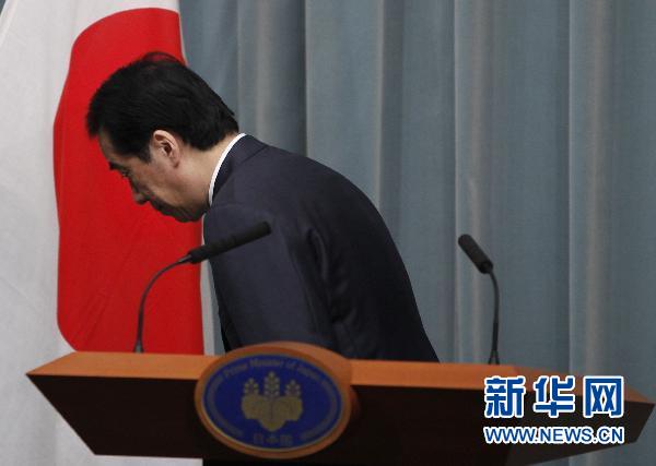 6月27日，在日本东京，日本首相菅直人在新闻发布会上向国旗致敬。　日本首相菅直人27日晚小幅改组内阁，原环境大臣松本龙出任复兴担当大臣，负责灾后重建，原首相特别助理细野豪志出任同为新设职位的核电站担当大臣。 