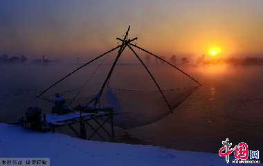 傍晚的江边，太阳徐徐落下，渔民打鱼的网呈现出美丽的剪影。中国网图片库天高摄影