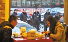 昨日下午，朝阳公园西门一春饼店顾客爆满，警察来到现场维持秩序。实习生 吴坚 摄