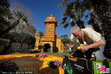 2012年2月16日，法国芒顿，工人们在比奥夫公园内为一年一度的柠檬节做准备。每年柠檬节都会吸引超过25万人来参观这里的花车巡游及水果景观。这些景观由300名工作人员参与搭建，会用上50万个产自台湾的橡皮筋及多达140吨的柑橘类水果。图：Patrick Aventurier/Getty Images/CFP