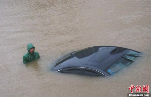 5月12日，江西遭遇新一輪強降雨襲擊，南昌等地出現短時強降雨，導致城區嚴重內澇，不少汽車在通過積水處因熄火被淹沒。圖為在南昌市紅谷灘新區豐和立交橋下一米多深的積水中，一米男子正在奮力推著被淹沒的小轎車。中新社發 劉虎 攝