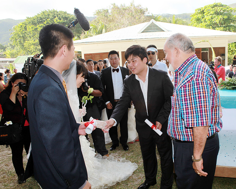  婚礼宣誓过后，塞舌尔前总统詹姆斯·孟肯爵士（右一）与北京强盛投资有限公司总经理岳宗朝（中）共同向20对新人颁发了结婚证书。 