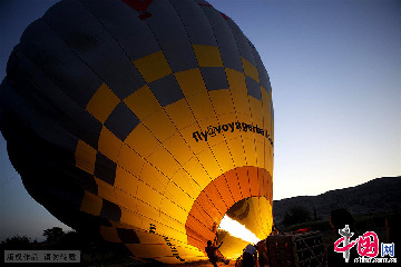 在格雷梅，乘坐热气球是一项非常重要的旅游项目。这是工作人员在为热气球点火充气。中国网图片库 栩同/摄