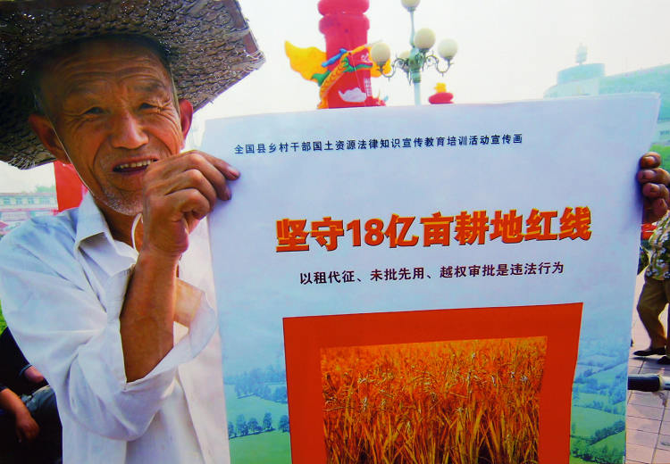纪检监察：农民手持“遵守18亿亩耕地红线”宣传画