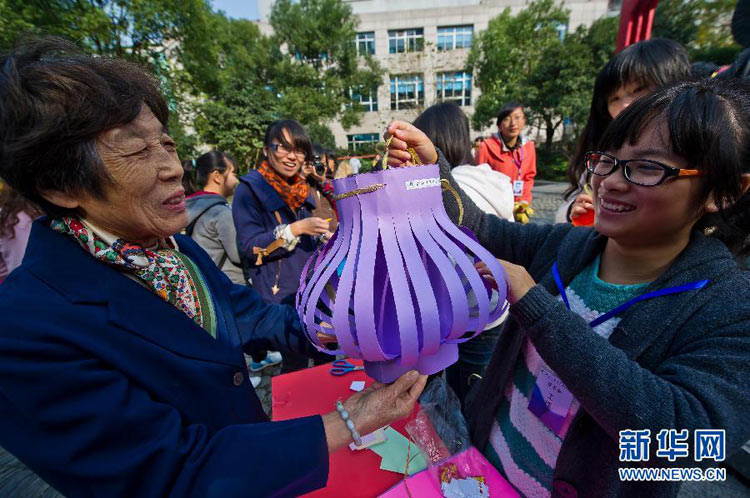 11月11日，75歲的吳世蘭老人（左）與大學生一起製作燈籠。