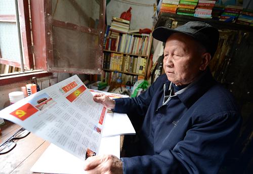 刘富祥老人在家中查看印好的简报（12月3日摄）。新华社记者 周科摄