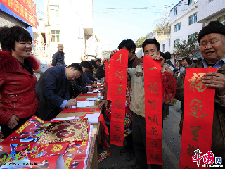  2013年1月30日，巧家縣金塘鎮的農民拿著免費贈送的春聯、福字，滿臉笑容。中國網圖片庫 閆科任 攝影。