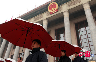 工作人员在雨中打伞迎接到会委员。中国网记者 杨佳摄影