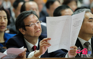 3月12日，中国人民政治协商会议第十二届全国委员会第一次会议在北京闭幕。图为参会委员阅读材料。人民画报 徐讯摄影