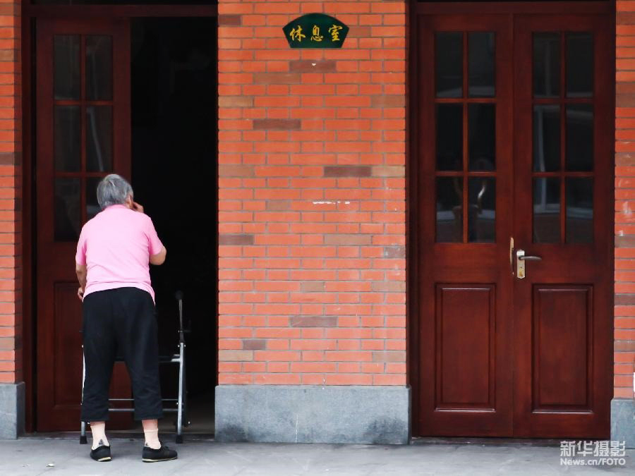 一名老人在上海市静安区曹家渡街道日间“托老所”内准备去休息室睡午觉。这家日间“托老所”提供“助餐、助医、助浴、助行、助急”等十助养老服务（2012年7月9日 新华社发 钮一新 摄）。