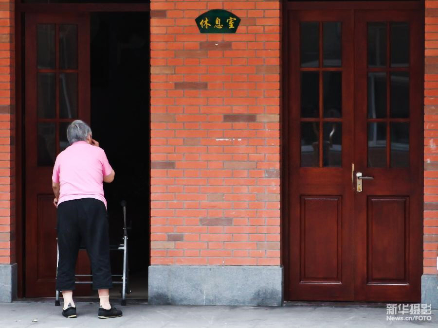  一名老人在上海市靜安區(qū)曹家渡街道日間“托老所”內(nèi)準(zhǔn)備去休息室睡午覺。這家日間“托老所”提供“助餐、助醫(yī)、助浴、助行、助急”等十助養(yǎng)老服務(wù)（2012年7月9日 新華社發(fā) 鈕一新 攝）。