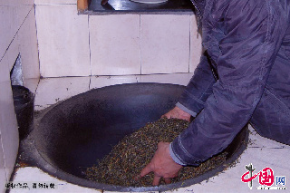经过两次杀青、揉制后的茶叶入锅，用文火慢慢烘焙至干燥。中国网图片库 吴春平摄
