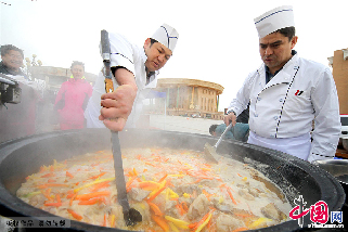 两位厨师正在熬制做抓饭的胡萝卜和羊肉。 中国网图片库/蔡增乐 摄