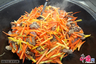 3月21日，正在炒制做抓飯的胡蘿蔔和羊肉。 中國網圖片庫/蔡增樂 攝