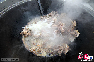 3月21日，新疆哈密木卡姆传承中心的的广场上正在炸制做抓饭的羊肉。 中国网图片库/蔡增乐 摄
