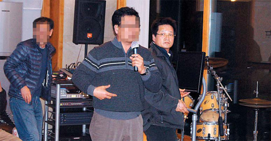 房地产暴发户尹重千(右)去年3月在别墅内的练歌房举行战友聚会