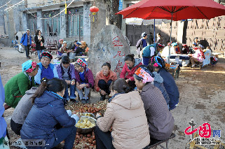 玉几岛上的白族土著居民围坐在一起削土豆。中国网图片库 李刚摄影