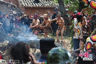 2013年3月14日，云南弥勒县，红万村祭火节，龙树下，钻木取火成功后，小伙子们围着龙树狂舞，嘴里不停的发出“嗷嗷”的声音。中国网图片库 何东平摄