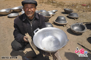 贾国良师傅和他制作的铝锅。中国网图片库 赵玉国摄