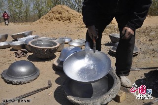 賈國良師傅從模具中拿出製作好的鋁鍋。中國網圖片庫 趙玉國攝