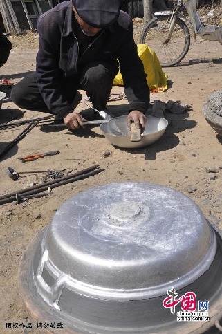 贾国良师傅在加工打磨铝锅。中国网图片库 赵玉国摄 