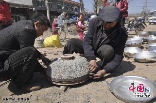贾国良师傅在用传统手艺为乡亲 “倒铝锅”。中国网图片库 赵玉国摄