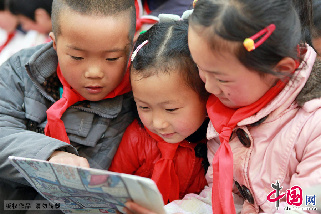 4月11日，在安徽宿州市桃園鎮邱寨希望小學留守兒童“光明驛站”，同學們正在認真閱讀農村“孩子報”。中國網圖片庫 馬勇 攝