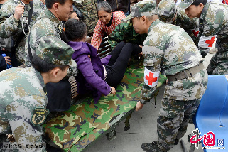 4月22日，武警水电部队医务人员在地震区宝盛乡抢救一个突然因心脏病晕迷的孕妇。中国网图片库 钟桂林 摄