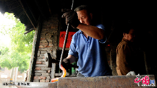 宗师傅负责铁艺制作，把加热好的铁料逐一的制作成农工用具。 中国网图片库/王海滨 摄