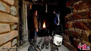 这一天烘炉又在开始营业，宗师傅和大妈在等待着炉温起来。 中国网图片库/王海滨 摄