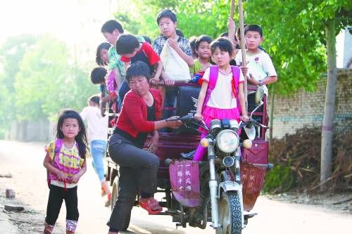 村妇开1辆三轮摩托车载31名孩子上学