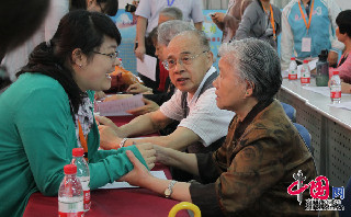 图为社区工作人员帮助社区老年人代表现场填写问卷调查。中国网记者 杨楠摄影