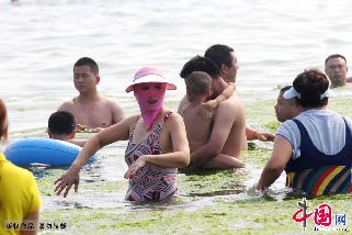 穿着脸基尼的泳客在青岛第一海水浴场消暑休闲。中国网图片库/黄杰显 摄