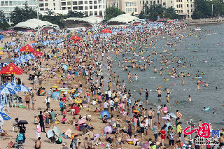 2013年7月7日，人们在青岛第一海水浴场戏水消暑。中国网图片库 黄杰显摄影