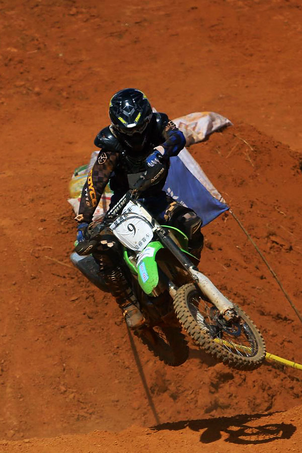 摩托车越野赛车手为陕汽杯2013全国超级卡车大赛湖南新田站决赛加油