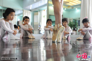 舞蹈老师张馨滢在为孩子们展示芭蕾舞动作：脚尖着地。   中国网图片库  赖鑫琳/摄