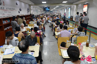 7月15日，市民在人民广场人防纳凉点看书，聊天抵御高温。中国网图片库 钟桂林摄