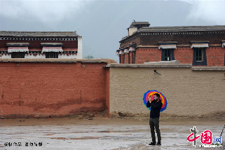 7月14日，甘肃省甘南藏族自治州夏河县，一名外国游客在的拉卜楞寺内游览拍照。 中国网图片库 赖鑫琳 摄