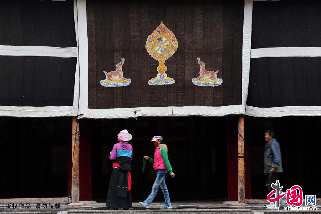 7月14日，甘肃省甘南藏族自治州夏河县，几名朝拜者在拉卜楞寺内转经。 中国网图片库 赖鑫琳 摄