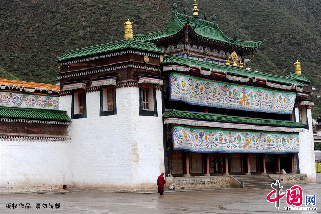 7月14日，甘肃省甘南藏族自治州夏河县，一位喇嘛经过拉卜楞寺的一座宝殿。 中国网图片库 赖鑫琳 摄