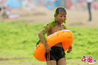 2013年7月18日，青島，一名男孩身上沾滿滸苔。  中國網圖片庫 王海濱 攝影