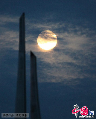 7月22日晚，黑龙江省大庆市一雕塑与超级月亮相映成趣。中国网图片库 韩兴华摄