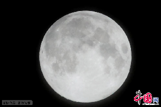 2013年7月22日23时07分，吉林省吉林市一轮圆月透过云层出现在夜空。中国网图片库 朱万昌摄