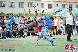 新疆哈密巴里坤哈萨克自治县2013少数民族传统体育运动会上，选手正在进行摔跤比赛。  中国网图片库   李华/摄