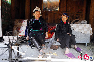 一名侗族妇女正在用木制纺纱机将棉花纺成纱线。  中国网图片库   赖鑫琳  摄