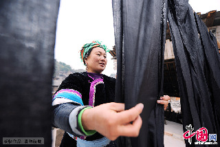一名侗族妇女正在晒土布。   中国网图片库  赖鑫琳  摄