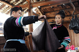 两名侗族妇女在丈量侗布,准备裁剪、缝制。  中国网图片库  赖鑫琳  摄