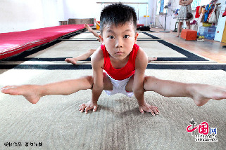7月30日，在安徽省亳州市文帝东路亳州体操训练基地体操馆内，孩子们正在教练的指导下强化训练。图为受训的小队员在练习中。中国网图片库 刘勤利摄